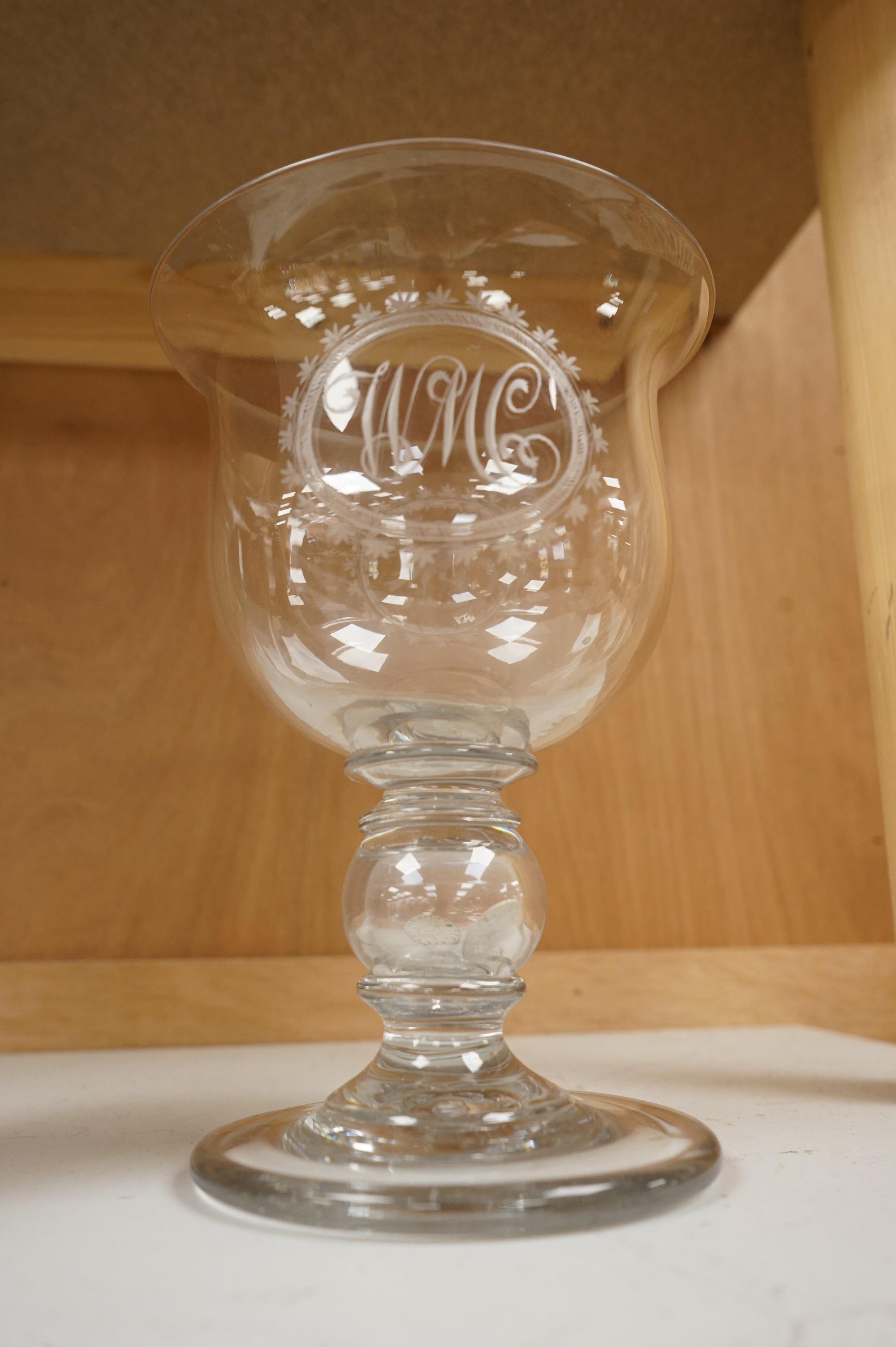 A large George III glass goblet, with inset coins to the hollow ball knopped stem, engraved with a parrot and the initials WMC, 20cm high